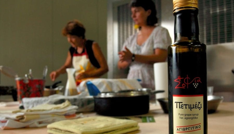close-up of a bottle with two women cooking at 'Wisdom of Nature'